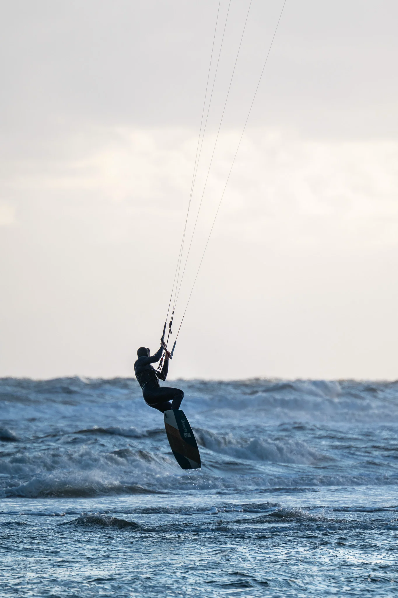 Kitesurfer als Silhouette gegen die Sonne bei hohem Wellengang